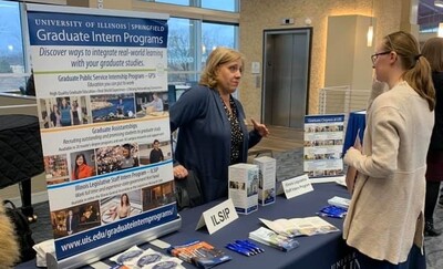 Sherrie Elzinga speaking with a student at a UIS Graduate Student Fair