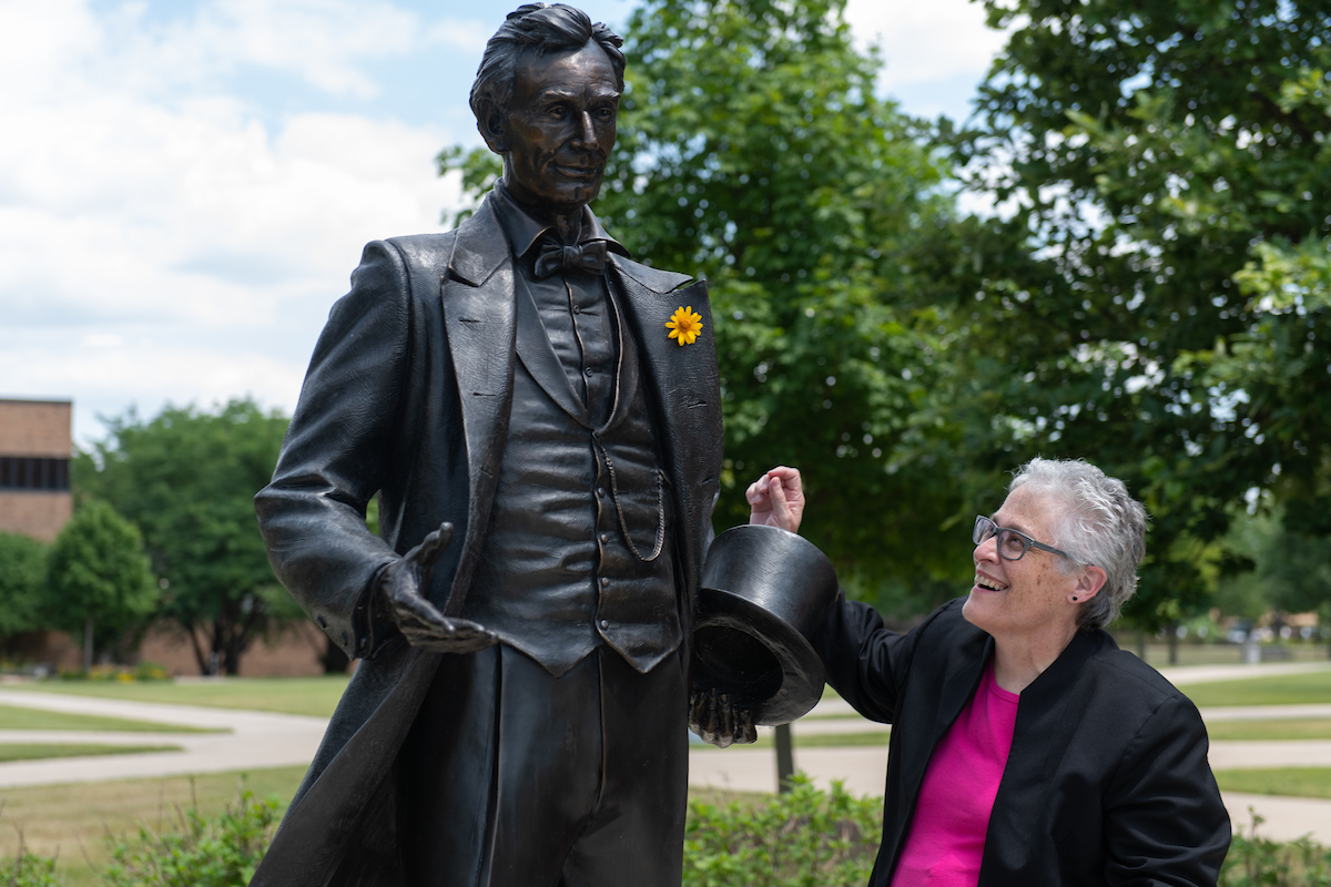 Interim Chancellor Karen Whitney, Ph.D., with the young Abraham Lincoln statue on the UIS quad