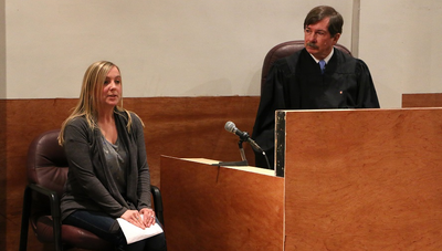 Photo of a woman in the witness seat and a judge in the UIS DCFS Mock Courtroom, part of the Child Advocacy Studies Program
