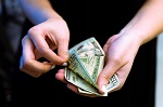 Photo of woman's hands holding dollar bills