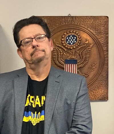 Image of Dean Robert Smith in his office wearing a Ukrainian flag t-shirt