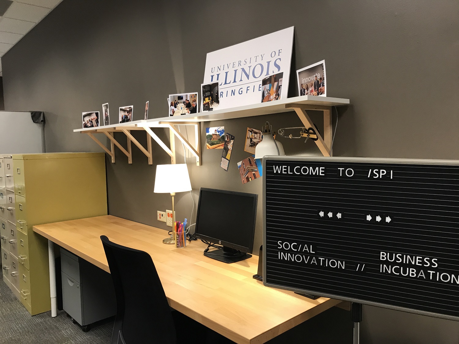 Sign with "Welcome to iSPI.  Social Innovation.  Business Incubation" in front of desk at the Innovate Springfield office